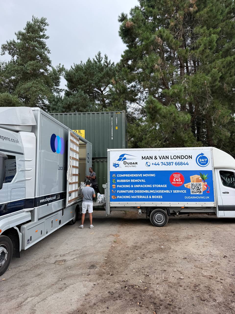 Two Dudar Moving vans transferring a load at a storage yard